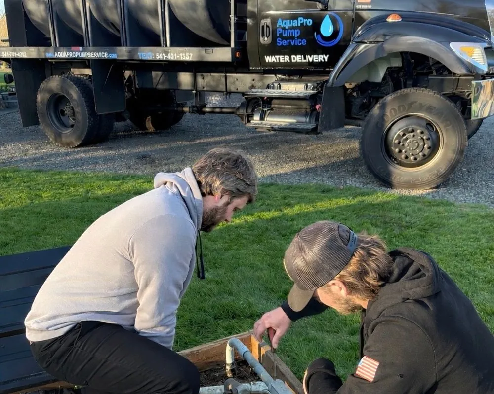 Aqua Pro Pump Service technicians repairing a well pump on-site in Albany, Oregon